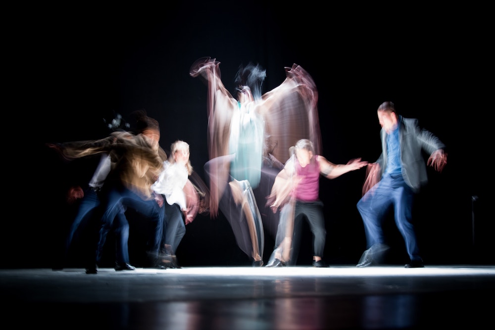 dancers blurred by motion on a stage