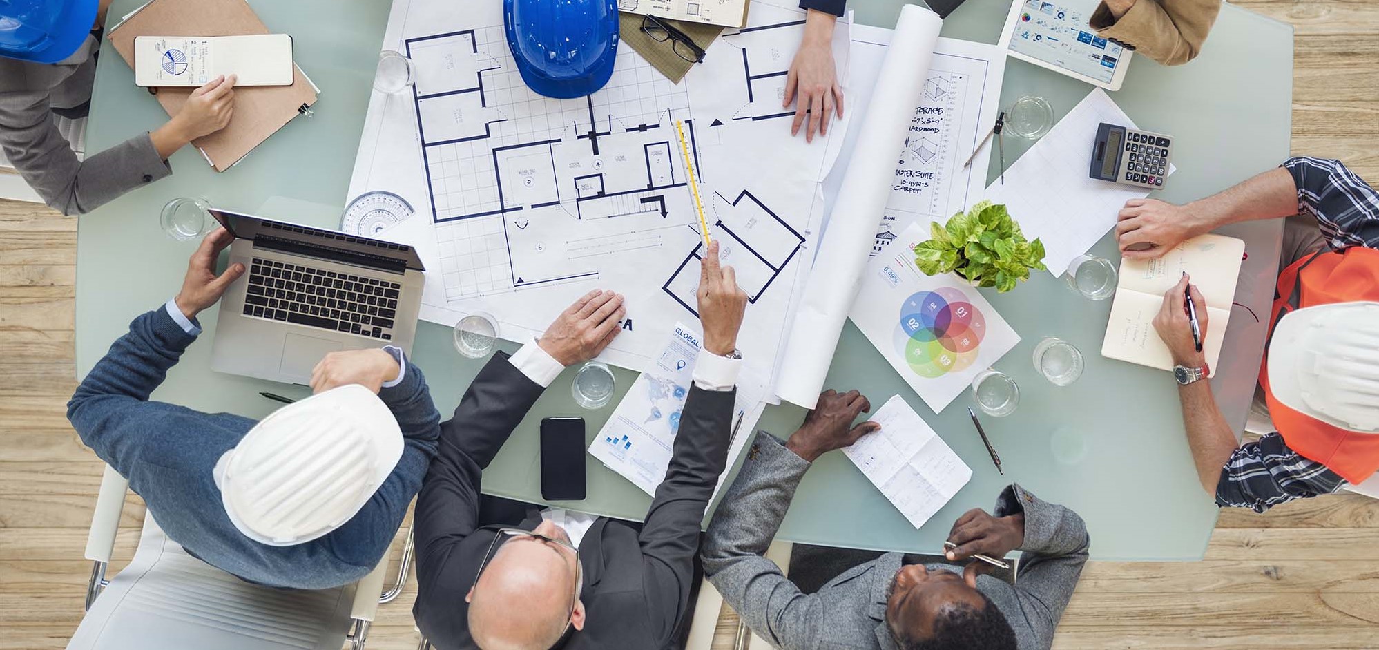 Architects and engineers seated at a table with drawings
