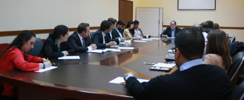 Growth Lab interns seated at table with Ricardo Hausmann
