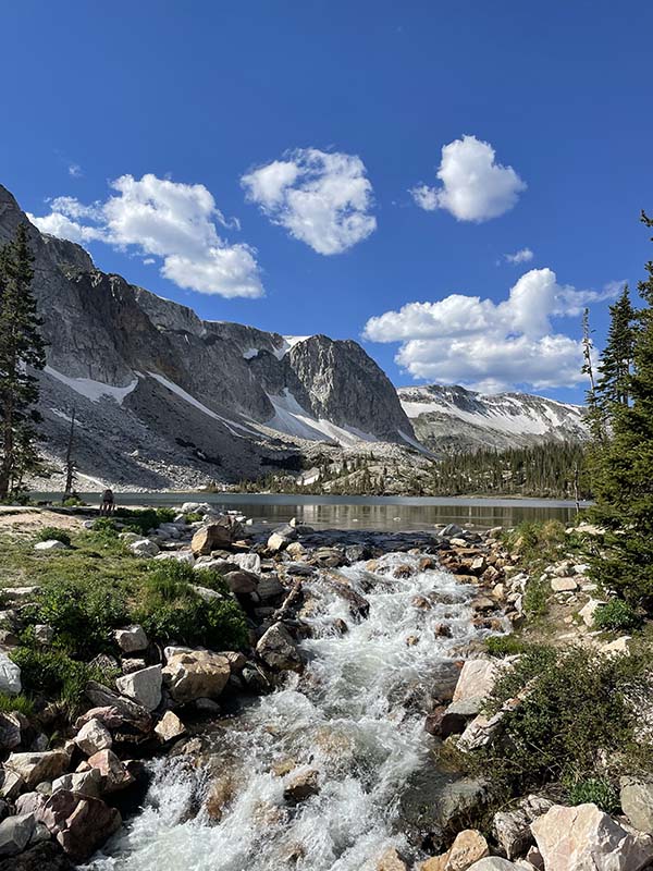 A stream, a large body of water, and a ridge of mountains