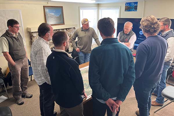 Growth Lab researchers and members of the Shoshone Arapaho Fish and Game look down upon a map on a table