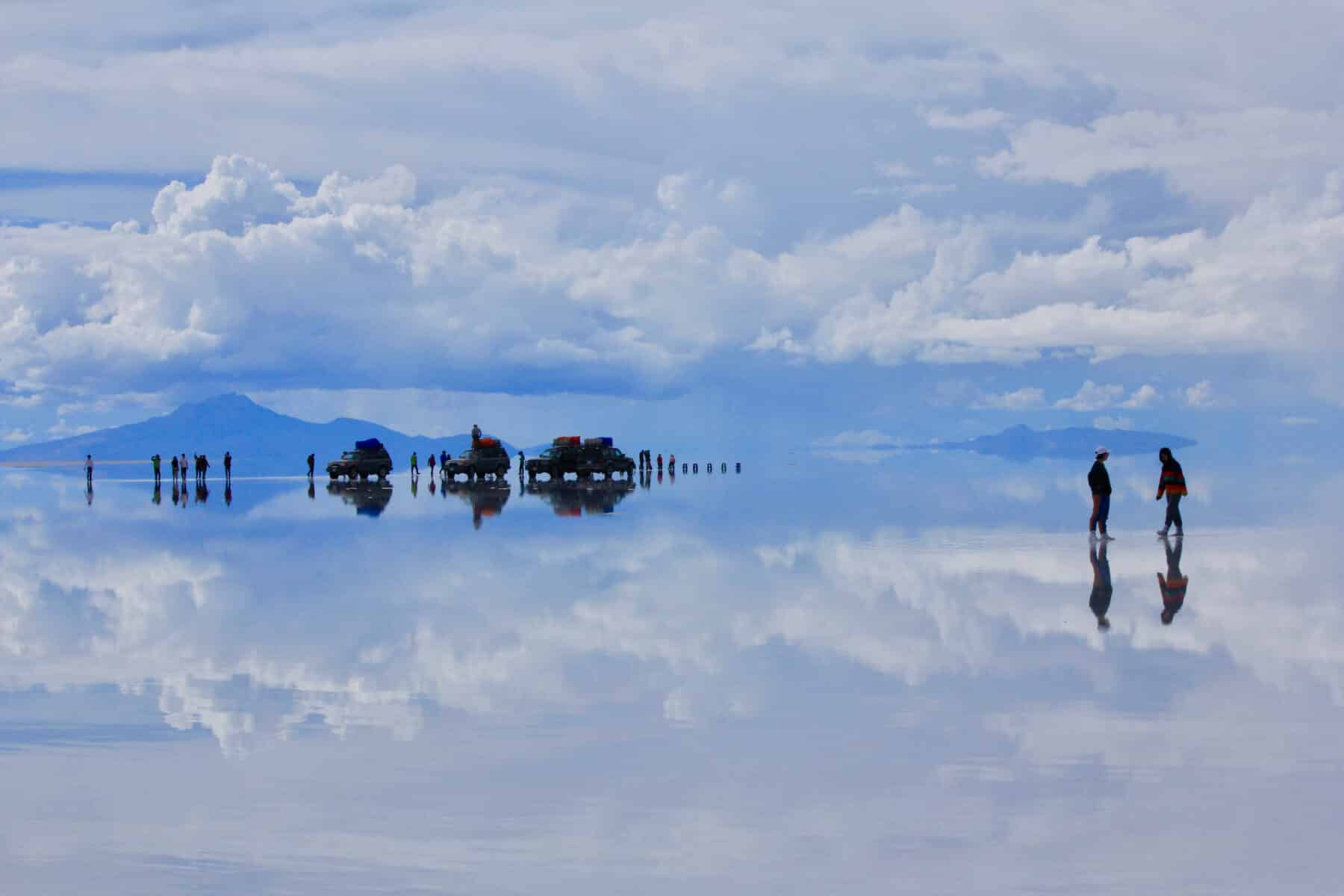 Silouettes of people and cars at the Uyuni Salt Flat in Bolivia.
